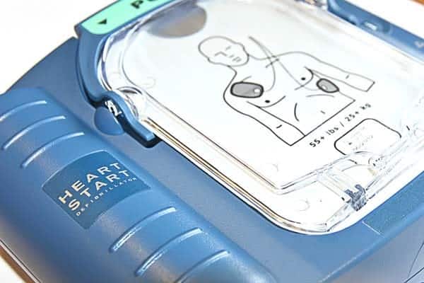 HeartStart defibrillator with a clear display showing a human torso and electrode pad placement.